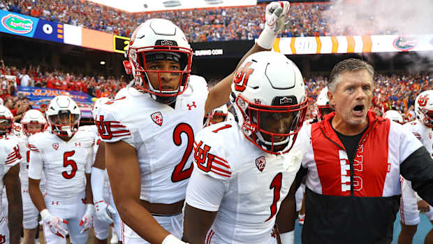 Utah Utes head coach Kyle Whittingham and teammates runs onto the field prior to the game against the Florida Gators at Steve Spurrier-Florida Field.